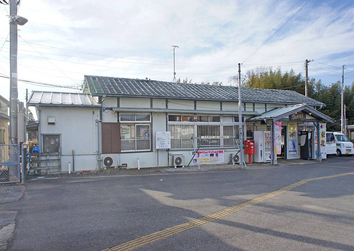 JR久留里駅の駅舎。瓦屋根の平屋の木造風の建物で、駅前に広いロータリーがある