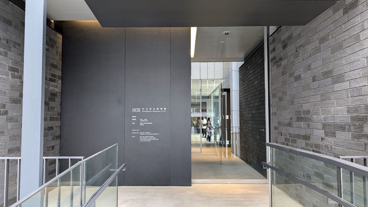 川口市立美術館のリリア側の入口。黒い壁に館名の表示があり、ガラス扉の奥に館内が見える