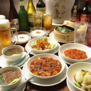 川菜味のコース料理と飲み物。麻婆豆腐や炒め物、スープが並ぶ