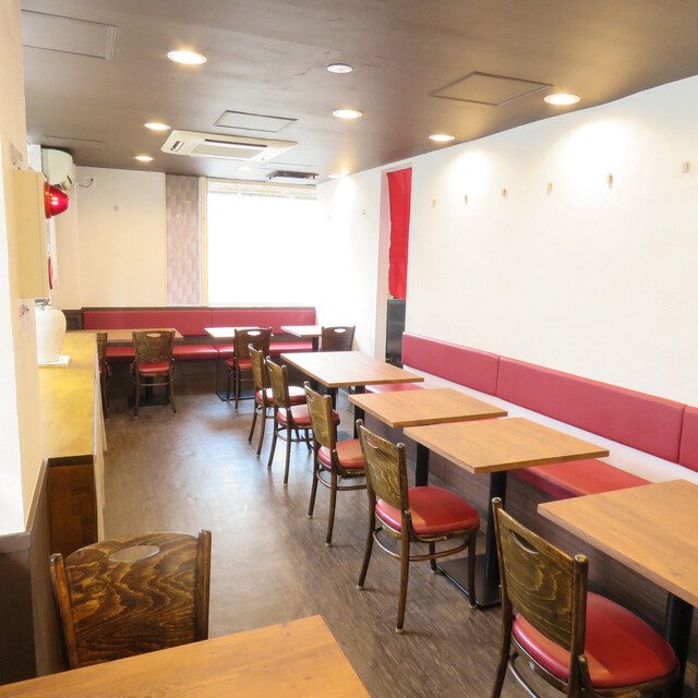 湊町に移った川菜味の店内。赤いベンチシートのテーブル席が並ぶ