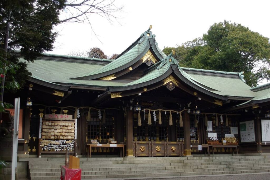 検見川神社の拝殿。緑青色の屋根が重なる社殿の前に石段があり、左手に絵馬掛けが並ぶ