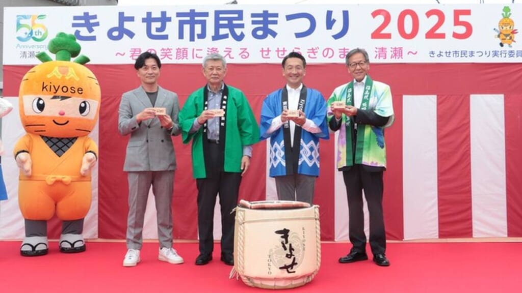 きよせ市民まつり2025の幕の前で、ニンニンくんと法被姿の来賓が並ぶステージ