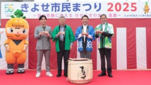 きよせ市民まつり2025の幕の前で、ニンニンくんと法被姿の来賓が並ぶステージ