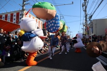 中山道の歩行者天国を進むパレード。こうのとりの着ぐるみと沿道の見物客