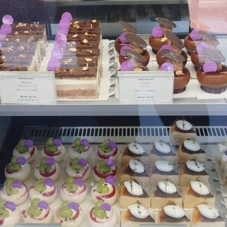 ショーケースの上段にマルジョレーヌ（税込700円）とトリアノン（税込750円）、下段にシャインマスカットをのせたムースとバスクチーズケーキが並ぶ