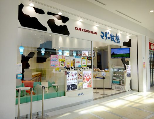 ガラス張りの店頭に牛柄の装飾と「CAFE & SOFTCREAM」の看板がある店舗