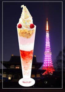 背の高いグラスにソフトクリームとフルーツを重ねたパフェと、背景の夜の東京タワー