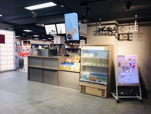 黒い天井の下にカウンターとショーケース、メニューのスタンドが置かれた店頭