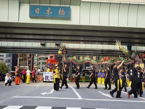 日本橋の銘板の下、中央通りで龍を操る東龍倶楽部の長崎龍踊り