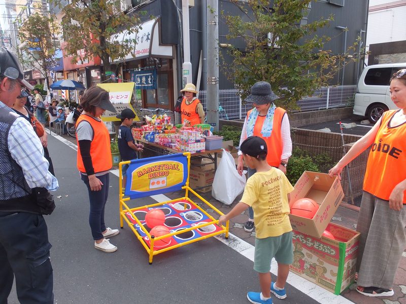 おいで通りに敷かれた線路を、子どもと大人を乗せた黄色いミニ新幹線が走る様子