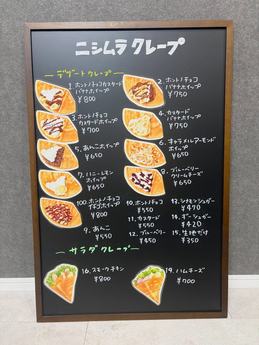 黒板に「ニシムラクレープ」の文字と、番号・商品名・値段が手書きされたクレープの写真付きメニュー。上がデザートクレープ、下がサラダクレープ