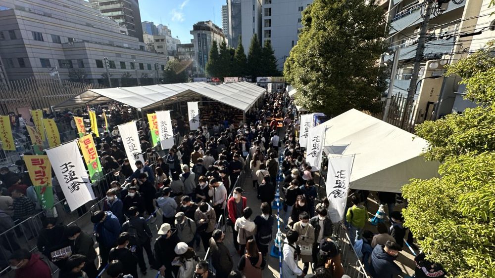 テントと店名ののぼりが並ぶ大久保公園の会場に、大勢の来場者が並んでいる様子