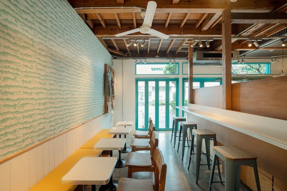 Pacific BAKERYの黄色いベンチとテーブル席、カウンター席