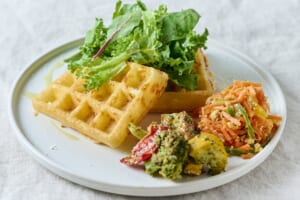 ワッフルと葉野菜、デリを盛り付けたプールジュールのランチプレート
