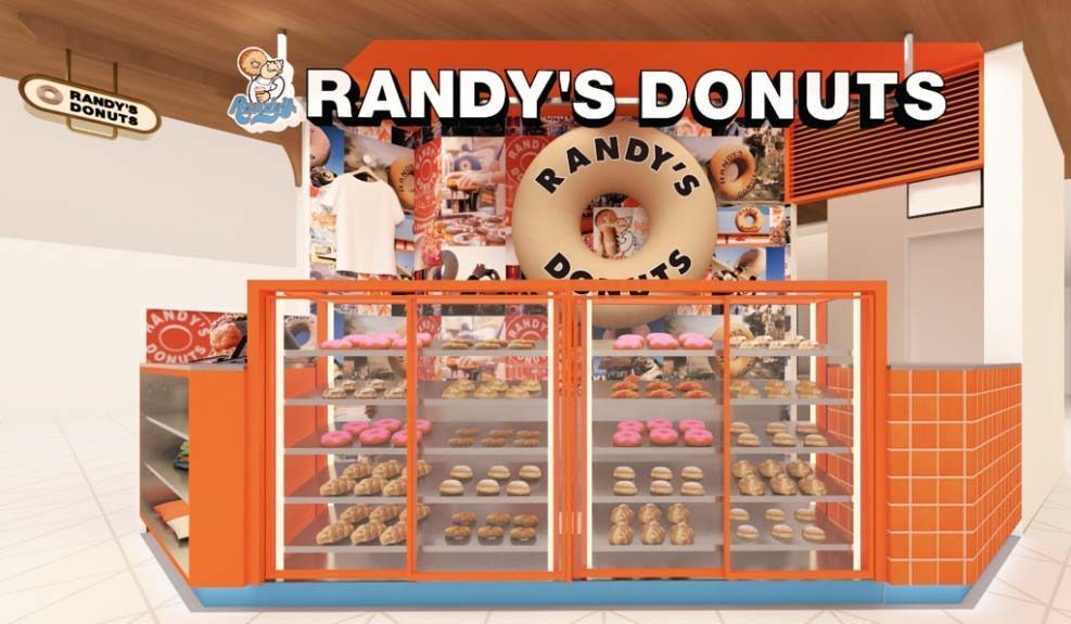 オレンジ色のショーケースにドーナツが並び、上部に大きなドーナツ型の看板とRANDY'S DONUTSのロゴがある売場の完成予想図