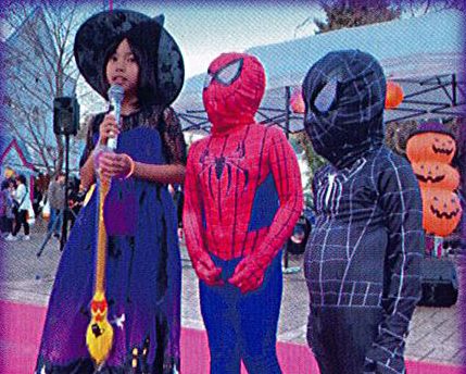 2024年の第3回さがみ湖Halloween Partyのチラシに載った過去開催の写真。魔女の衣装の女の子とスパイダーマンの仮装をした子どもたちがステージでマイクを持っている