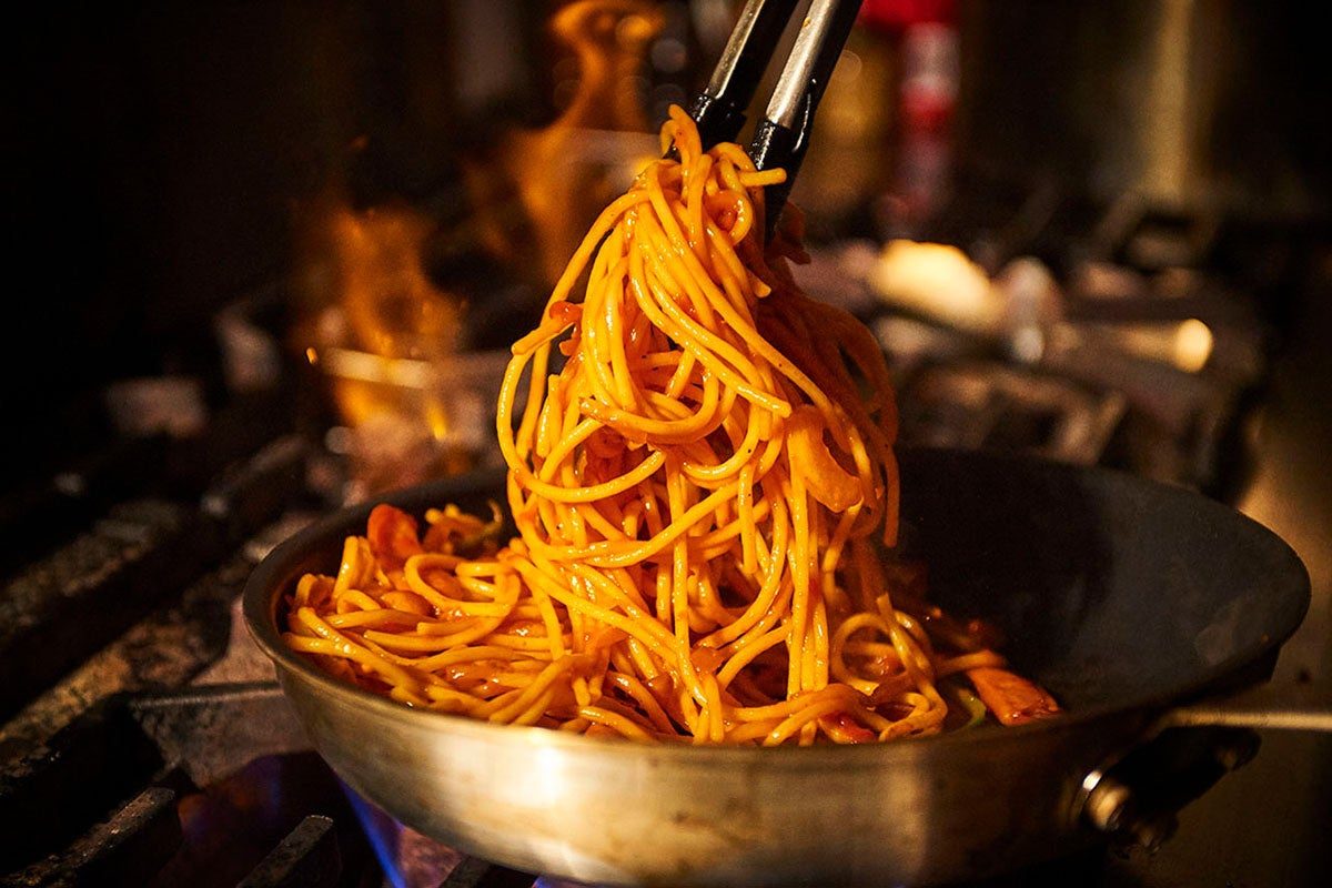 フライパンでナポリタンの麺を炒める様子