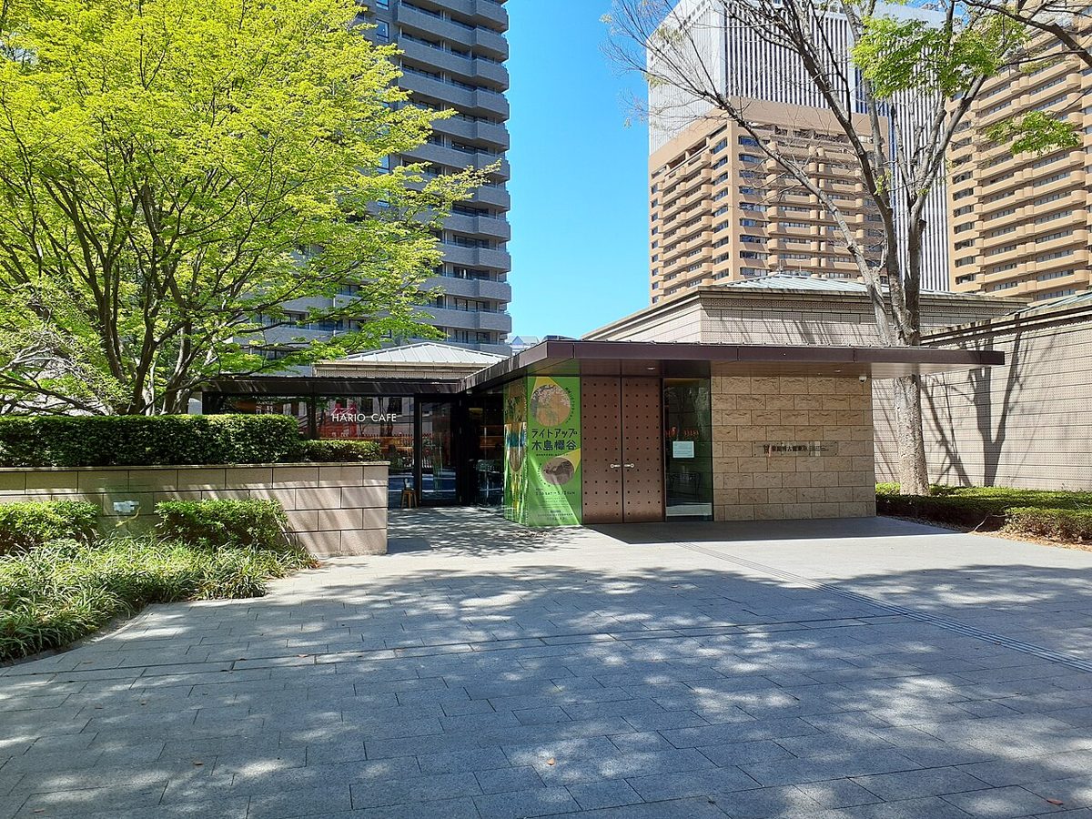 泉屋博古館東京の入口。高層ビルの手前にある低い建物と植え込み