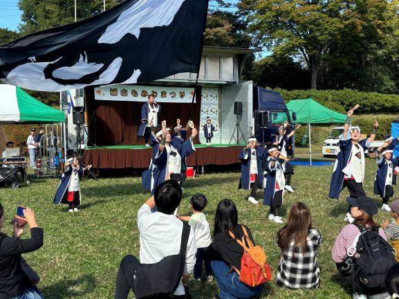 城山もみじまつりのステージ前の芝生で旗を振って踊るよさこいチーム(過去の開催時)