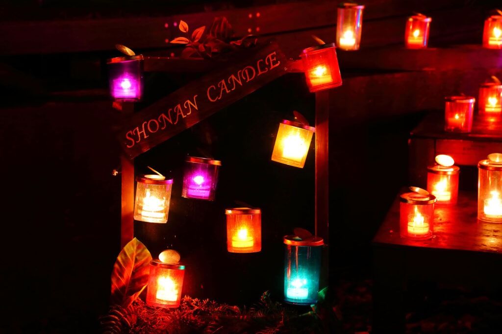 木の段に並ぶ赤や青のキャンドルと、SHONAN CANDLEと書かれた木の看板