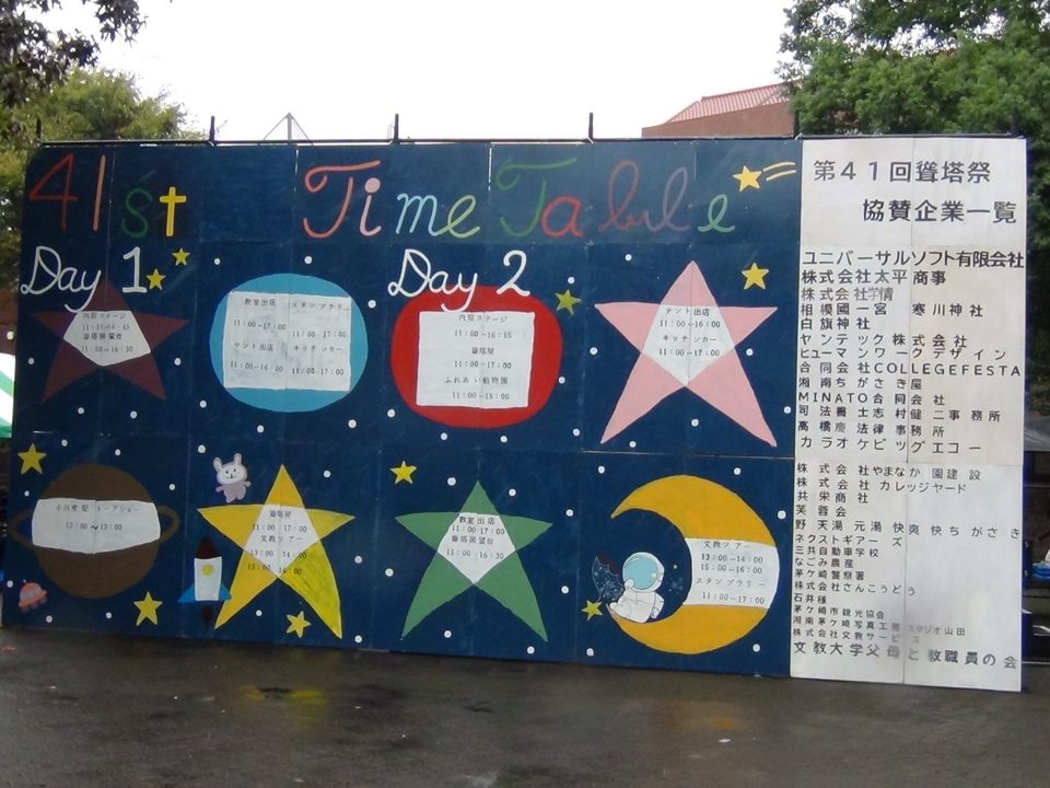 紺色の板に星や月の絵と「41st Time Table」の文字、Day1・Day2の内庭ステージや動物園、テント出店などの時間、右側に第41回聳塔祭の協賛企業一覧