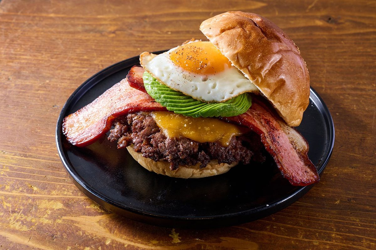 バンズに和牛パティ、チェダーチーズ、厚切りベーコン、アボカド、目玉焼きを重ねたハンバーガー
