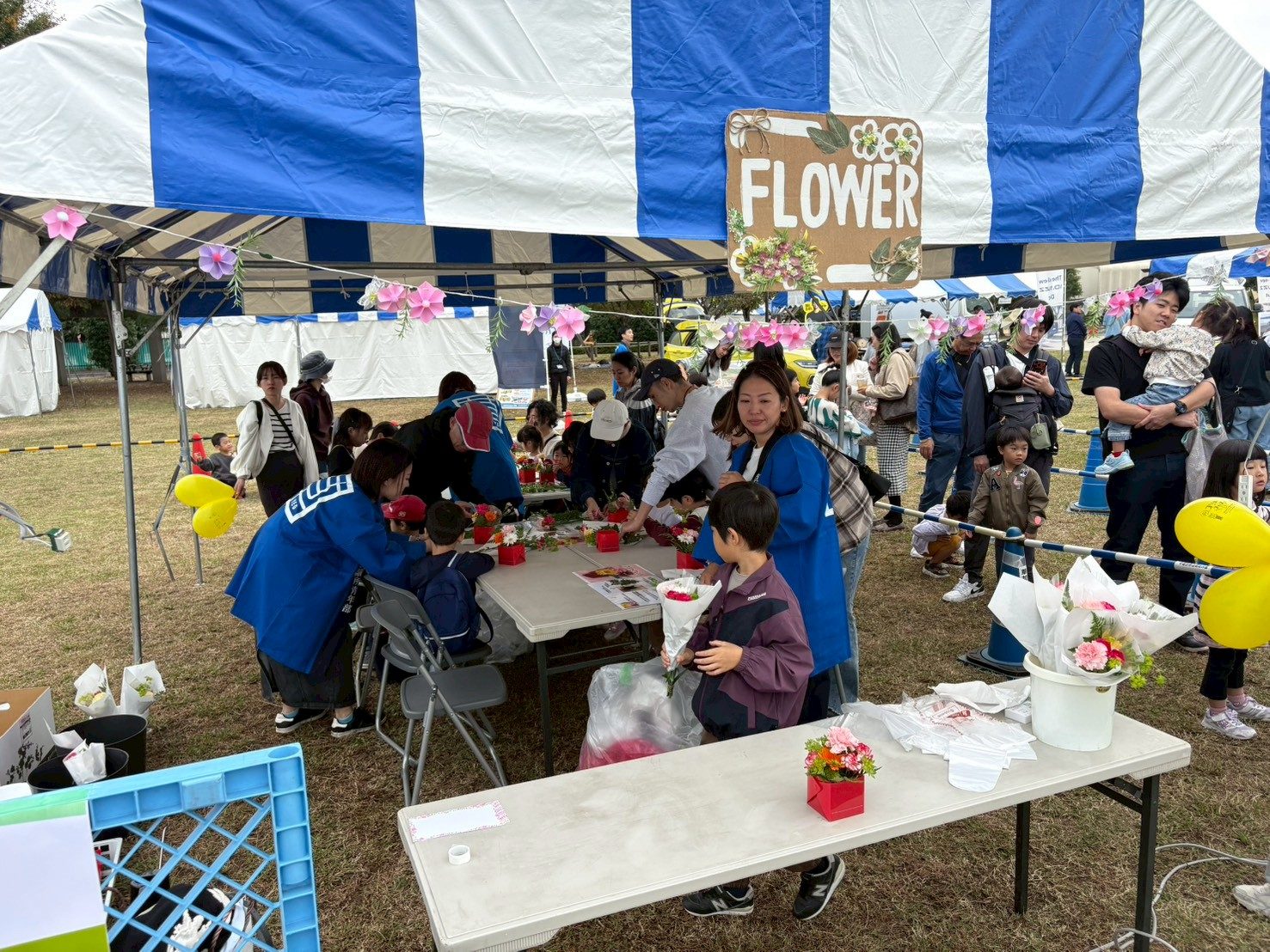 「FLOWER」の看板があるテントで、子どもたちが花を使った体験をしている様子