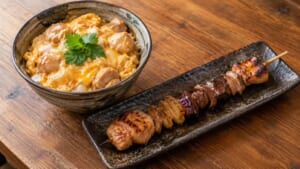 卵でとじた鶏の親子丼と、いくつもの部位を1本の串に刺した焼き鳥のイメージ画像