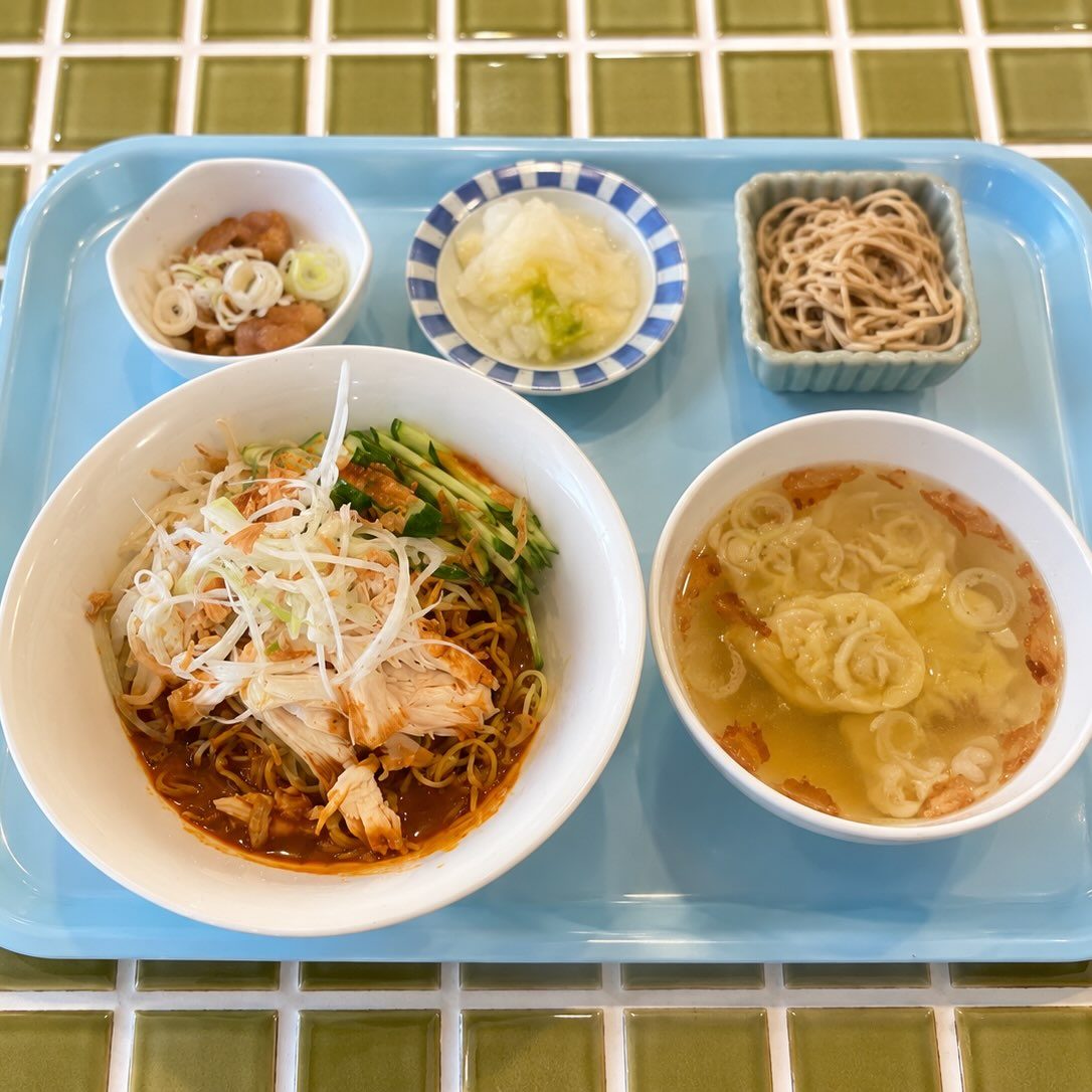 水色のトレーに蒸し鶏と白髪ねぎをのせた混ぜそば、ワンタンスープ、小鉢2品、漬物がのった昼のセット