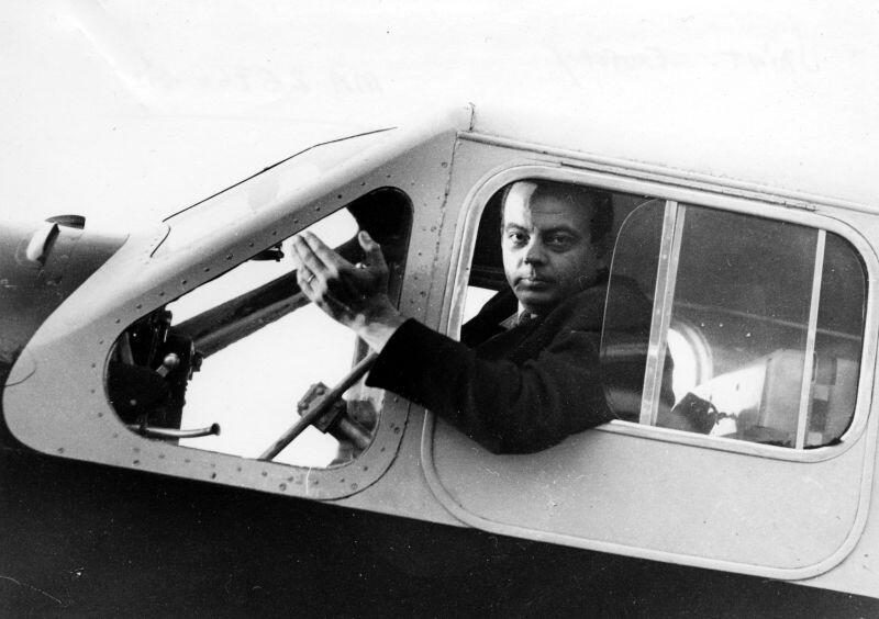 飛行機の操縦席の窓から身を乗り出すアントワーヌ・ド・サン=テグジュペリのモノクロ写真