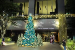 東京スクエアガーデンの入口前に立つ、緑と青の模様のクリスマスツリーのイメージ