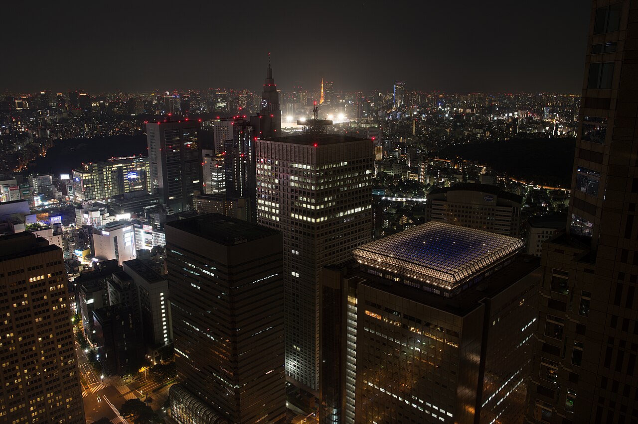 東京都庁の展望室から見た高層ビル群と遠方の東京タワーの夜景(2012年撮影)