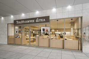 「TULLY'S COFFEE &TEA」の看板と、木目の内装・ガラス張りの客席が見える店の正面のイメージ図