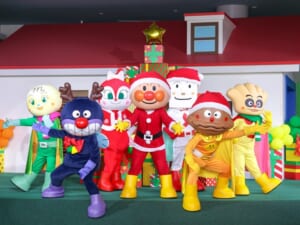 プレゼントの箱を積んだステージで、サンタ姿のアンパンマン、トナカイ姿のばいきんまん、ドキンちゃん、カレーパンマン、しょくぱんまんたちが並ぶ写真