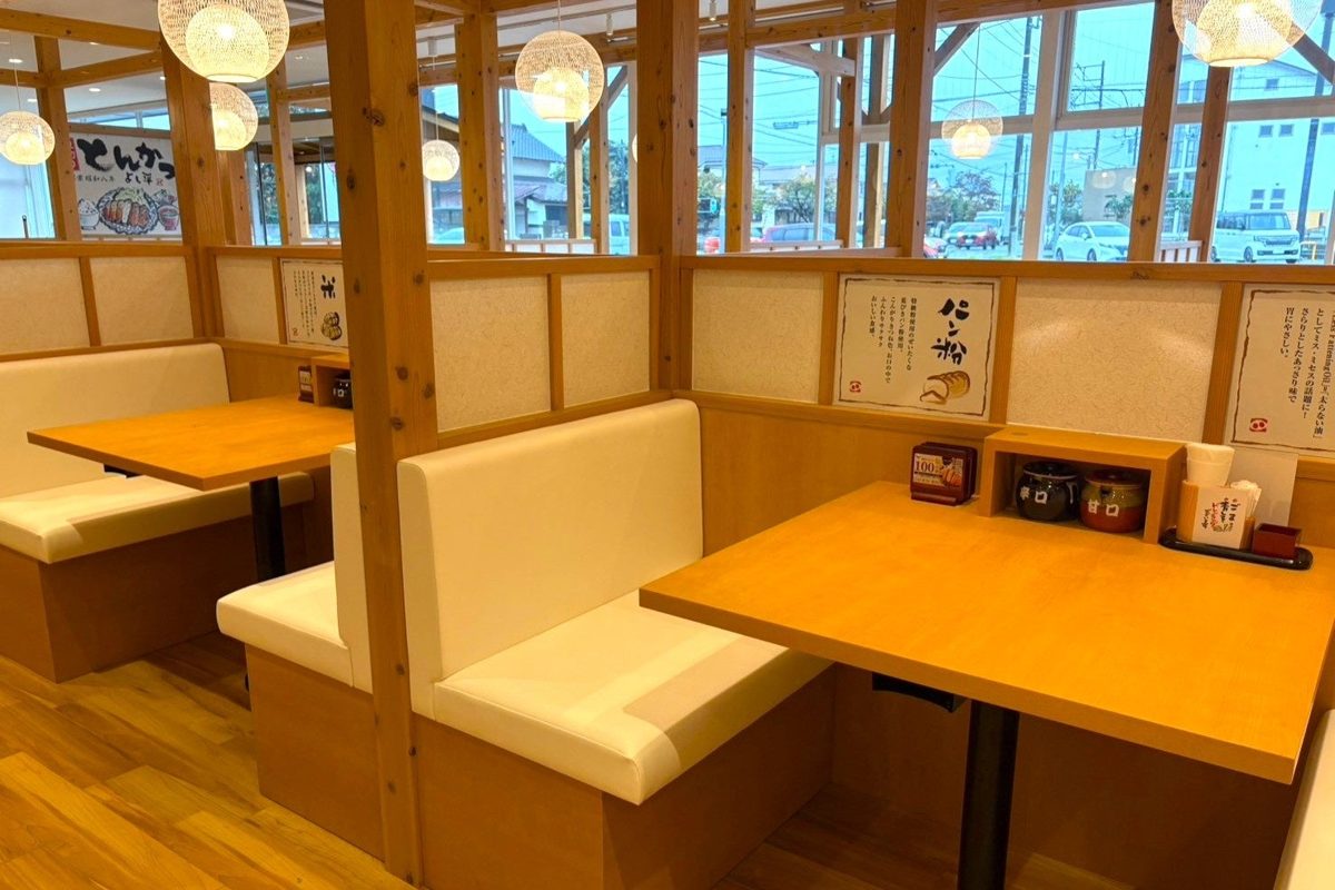 木の格子窓の前に並ぶ、クリーム色のソファのボックス席